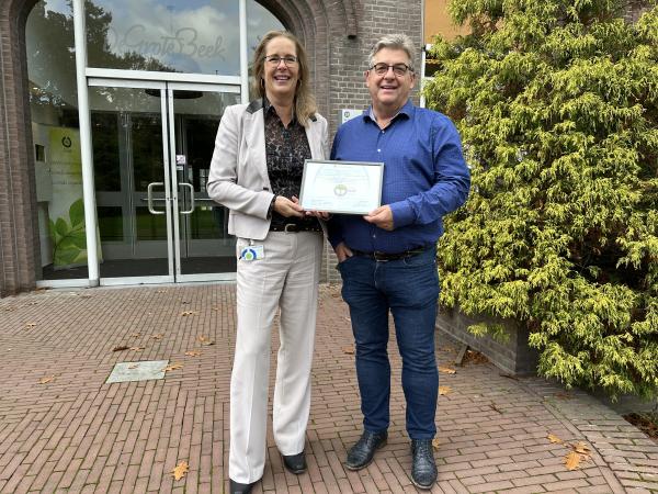 Thosha van der Maas (manager Servicecentrum, vastgoed en facilitair) en André Fransen (beleidsadviseur Servicecentrum) met het door Adriaan van Engelen (directeur van Milieu Platform Zorgsector) ondertekende zilveren certificaat. Zilveren certificaat Milieuthermometer